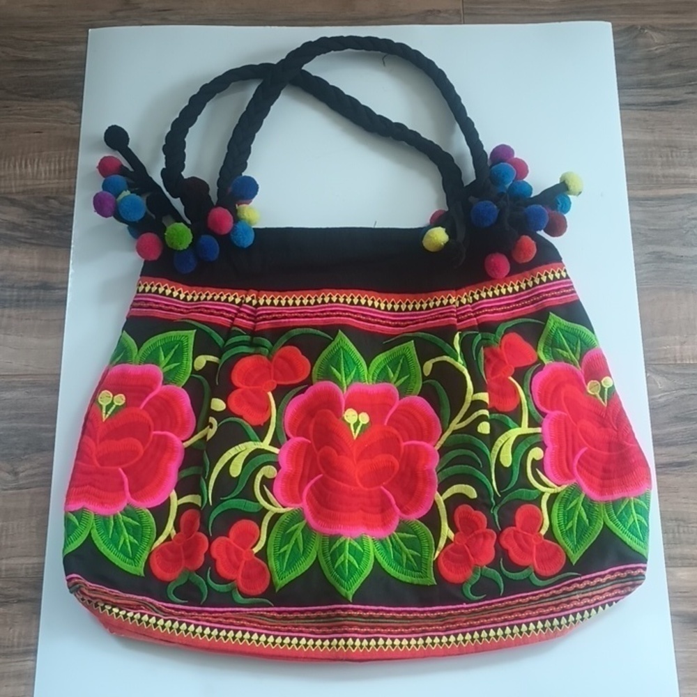 Bright black and floral embroidered zipper pocket tote bag with pom poms
